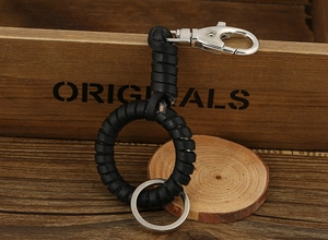 Detail of hand-woven black leather keychain with a metal spring lobster clasp and ring