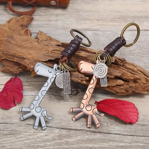 Retro giraffe leather keychain set in silver and bronze tones on wooden background