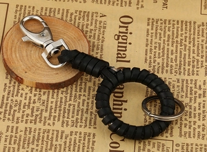 Handmade punk style leather keychain with silver lobster clasp on a vintage wood background