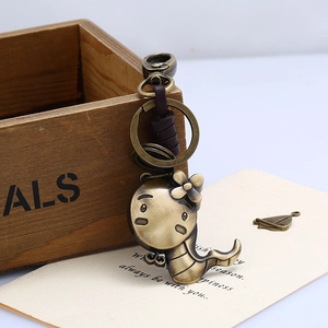 Macro view of brass cartoon snake keychain with vintage leather and metal ring details