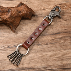 Detail of vintage leather skull keychain with metal hooks and spring snap hook