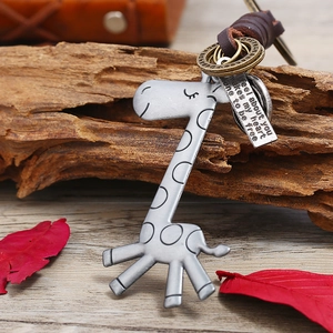 Retro giraffe leather keychain with alloy charm and inspirational tag on wood background