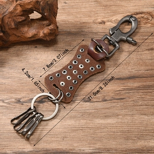 Retro punk genuine leather keychain with metal rivets and star studs on wood background