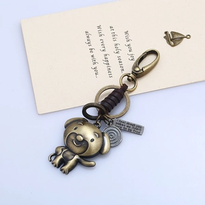 Detail of vintage bronze dog keychain with leather wrap and engraved metal charm tag