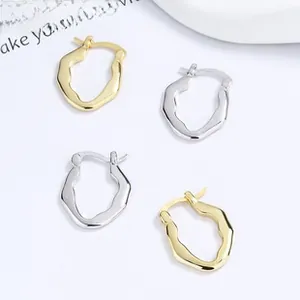 Detail view of gold and silver S925 sterling silver twisted wave hoop earrings set