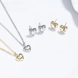 Detailed view of silver and gold heart jewelry set featuring sparkling micro-pave stones
