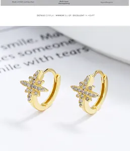Detailed macro of gold plated S925 sterling silver hoop earrings with star zirconia