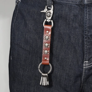 Punk skull leather keychain with silver hooks hanging on denim jeans loop