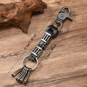 Punk style skull keychain in vintage silver metal and black leather on wooden background