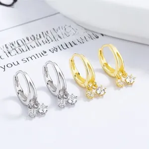 Detailed view of silver and gold tassel hoop earrings with sparkling zircon charms
