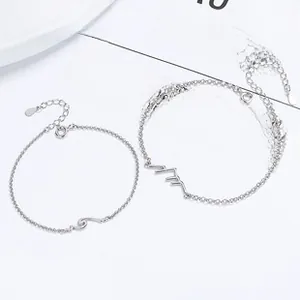 Close-up of 925 sterling silver Mobius bracelets with mountain and wave geometric charms
