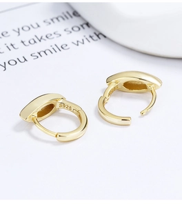 Macro view of wide gold-plated S925 sterling silver hoop earrings with secure clasp