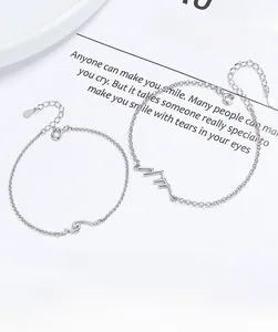 Detail of 925 sterling silver couple bracelets with mountain and ocean wave pendants