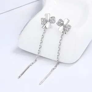 Vue macro des boucles d'oreilles en argent 925 à trèfle à quatre feuilles et pompons longs