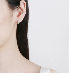 Macro detail of silver starburst hoop earring featuring micro-pave cubic zirconia accents