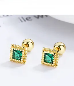 Macro detail of square emerald s925 silver stud earring with vintage gold bead texture