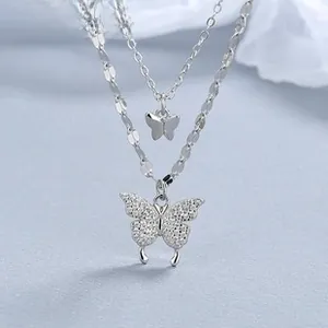 Détail d'un bracelet double couche en argent 925 avec pendentifs papillon scintillants et sequins