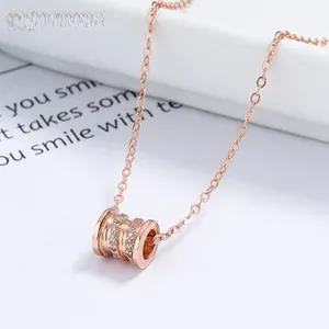 Macro shot of rose gold necklace with crystal pavé cylinder pendant and fine chain link