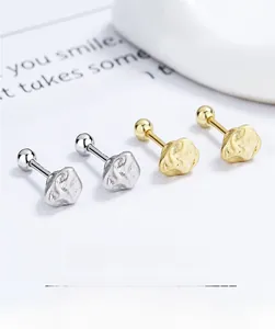Detailed macro view of irregular 925 silver stud earrings in gold and silver finishes