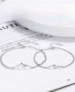 Close-up of S925 sterling silver couple bracelets with mountain and sea pendants