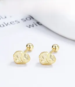 Close-up of golden irregular rock texture S925 silver stud earrings with screw backs