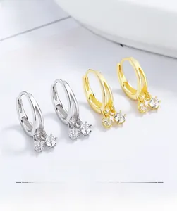 Détail de boucles d'oreilles créoles en argent 925 avec pompons en zircone doré et argenté