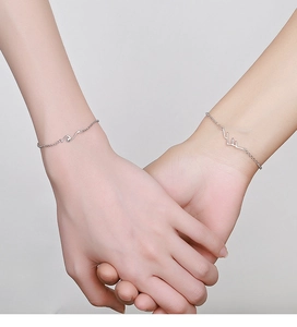 Close-up of minimalist S925 silver couple bracelets with mountain and heartbeat charms