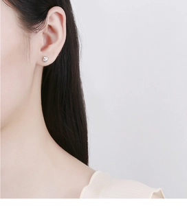 Close-up of 925 sterling silver irregular threaded stud earring on woman earlobe