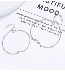 Detail of 925 sterling silver couple bracelets featuring mountain and wave engravings