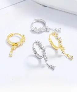 Detailed view of silver and gold drop tassel earrings with teardrop cubic zirconia stones