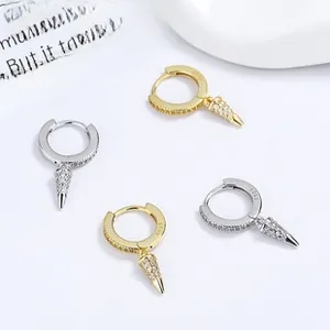 Macro detail of S925 silver hoop earrings with gold plating and paved zircon spikes