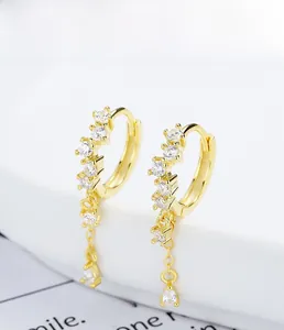 Detailed macro view of S925 sterling silver gold earrings with zircon drop tassels