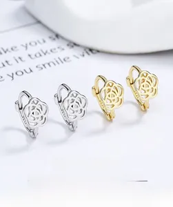 Macro shot of S925 sterling silver camellia earrings in gold and silver finishes