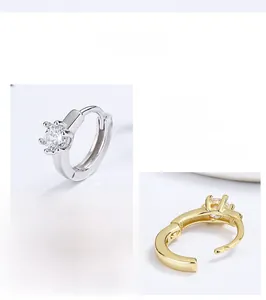 Detail of classic six-prong sterling silver and gold stud earrings with cubic zirconia