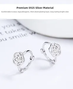 Macro detail of 925 sterling silver camellia earrings showing hollow rose carvings