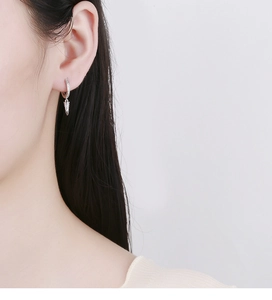 Vue détaillée de la boucle d'oreille créole en argent 925 avec pendentif cône pavé