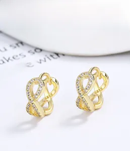 Macro shot of gold S925 sterling silver infinity earrings with inlaid white zircons