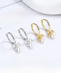 Detail of 925 silver pearl bow earrings in gold and silver finish with hoop closure
