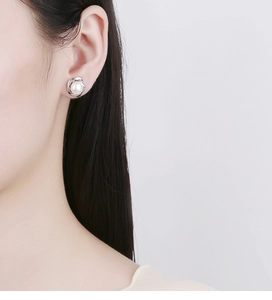Close-up of 925 sterling silver pearl stud earring with elegant twisted metal detail