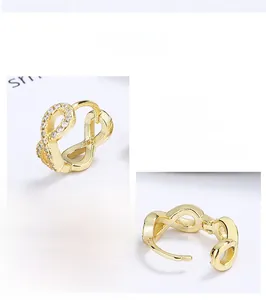 Macro detail of gold S925 sterling silver infinity earrings with white zircon accents