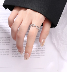 Détail d'une bague chaîne en argent avec cristaux pavés sur le doigt