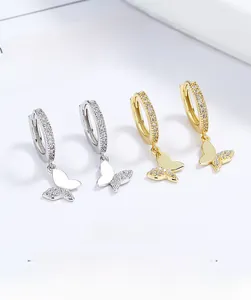 Detailed view of silver and gold butterfly hoop earrings with sparkling crystal inlay