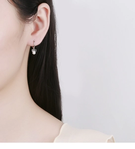 Close-up of a sterling silver butterfly pearl drop earring on a female model