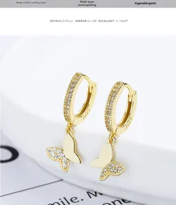 Detailed macro view of 925 sterling silver gold-plated butterfly hoop earrings with zircons
