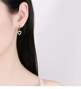 Close-up of 925 sterling silver heart hoop earrings with pavé stones on female model
