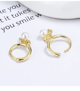 Detail of S925 sterling silver stamp on golden pearl butterfly hoop earrings