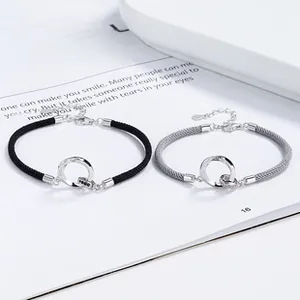 Macro detail of interlocking rings on braided Mobius couple bracelets in silver and black