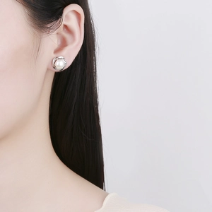 925 Sterling silver pearl stud earring with swirl metal design on a model