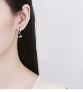 Close-up of 925 sterling silver butterfly hoop earrings with zircon on woman's ear