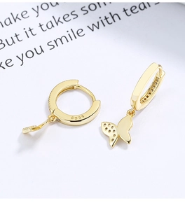 Close-up of golden butterfly drop earrings showing S925 hallmark and hollow wing details